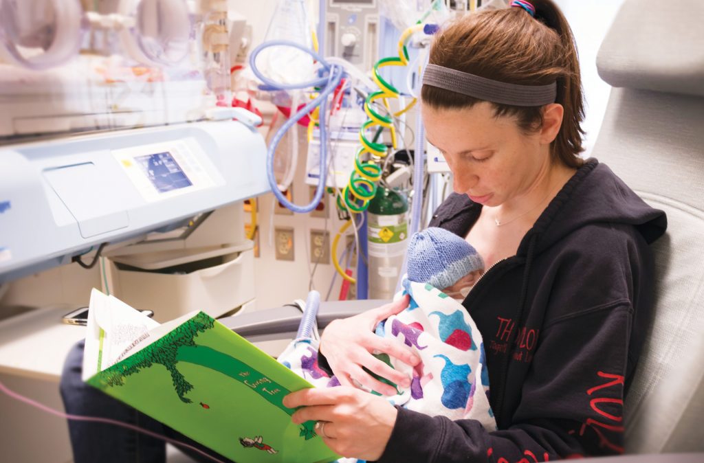 Mum reading book to baby on NICU 