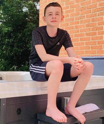 The image is of a teenage boy, sitting on the side of a pool, wearing a black t-shirt and shorts. This accompanies a blog post for the Noah's Ark Charity